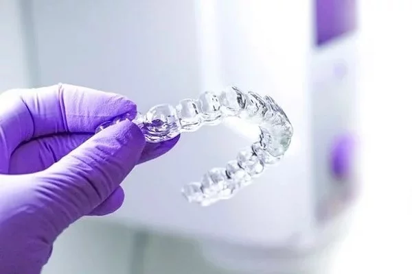 holding clear orthodontic aligner in hand